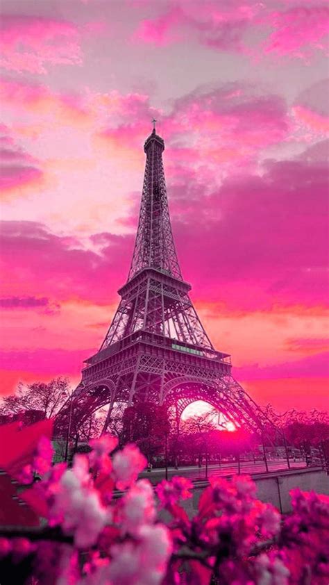 The Eiffel Tower In Paris France With Pink And Purple Clouds Above It