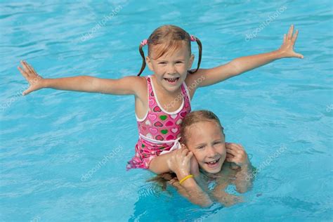 Two Little Girls Playing In The Pool — Stock Photo © Altanaka 27540649