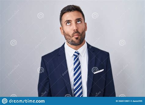Handsome Hispanic Man Wearing Suit And Tie Making Fish Face With Lips Crazy And Comical Gesture