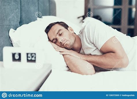 Person Sleeps Near Alarm In Bed With White Linens Stock Image Image