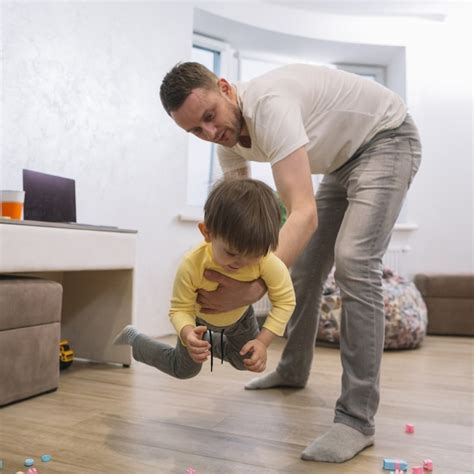 Padre Jugando Y Sosteniendo A Su Hijo Foto Gratis