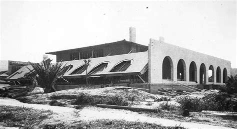 An Old Black And White Photo Of A Building With Arches On The Front