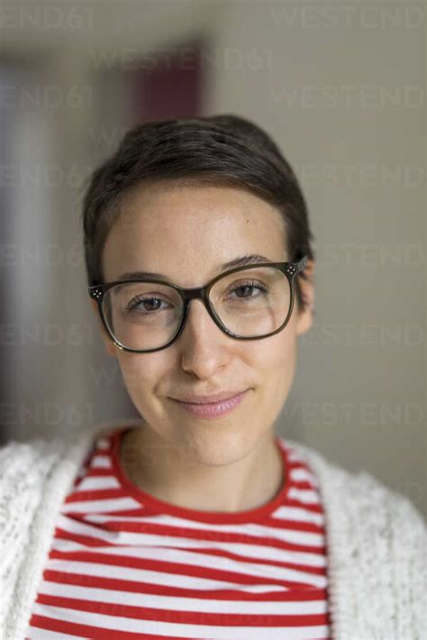 Portrait Of A Smiling Young Woman With Short Hair Wearing Glasses