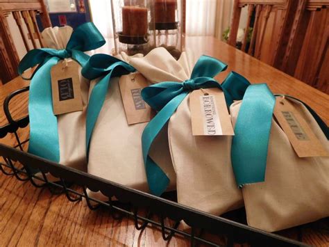 Four Wrapped Gift Bags Sitting On Top Of A Wooden Table Next To A