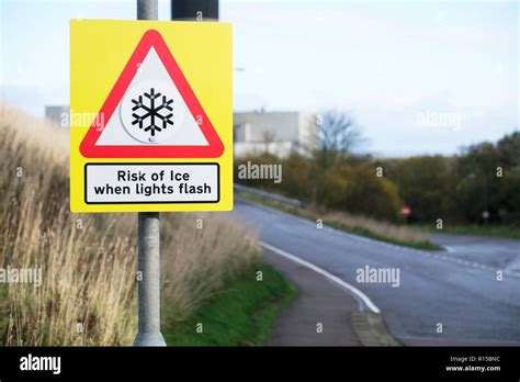 Risk of ice when light flashes winter road safety sign Stock Photo - Alamy