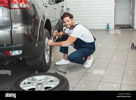 Young Handsome Mechanic Wearing Uniform Working In Car Service