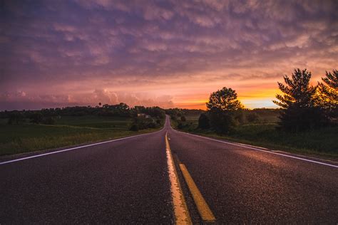 Foto De Carretera Vacía Entre Campo De Hierba Durante La Hora Dorada