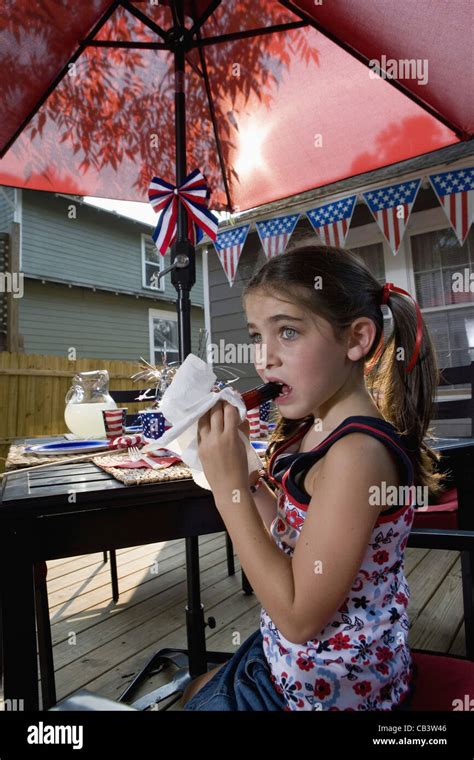 Girl Eating A Popsicle At Picnic Table In Backyard Patio With 4th Of