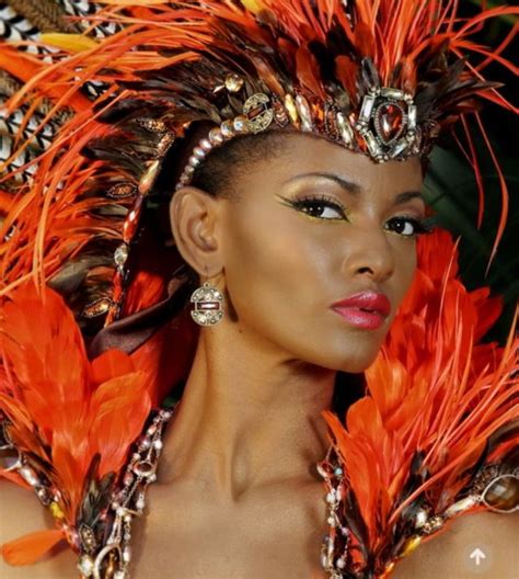 A Woman With Bright Orange Feathers On Her Head And Chest Wearing An Elaborate Costume