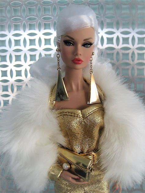 a barbie doll wearing a gold dress and white fur stole with golden jewelry on her neck