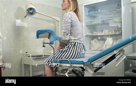 frauenarzt gefragt weiblichen patienten auf dem gynäkologischen stuhl für prüfung