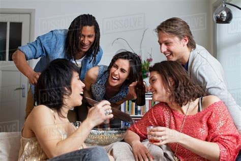 Friends Laughing Together In Living Room Stock Photo Dissolve