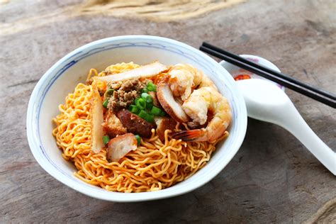 This simple dish consists of egg noodles that are tossed in sauce and topped or served with sliced barbecued pork (char siu), minced pork, and fried onions. Kolo Mee | Traditional Noodle Dish From Kuching, Malaysia