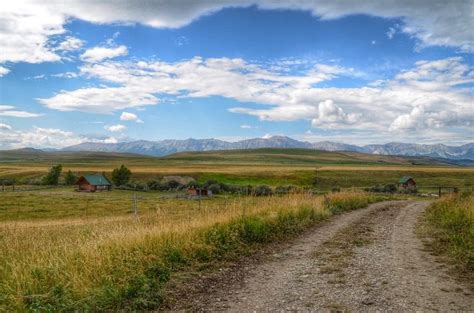 Sprawling Ranchlands And Mountain Foothills In Alberta Countryside
