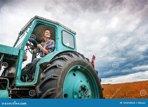 Young Beautiful Girl Working On A Tractor In The Field Unusual Stock