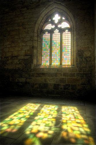The Sun Is Shining Through A Stained Glass Window In An Old Building With Stone Floors