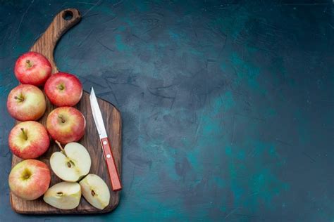 Vista superior maçãs vermelhas frescas suculentas e maduras com mesa marrom no fundo azul