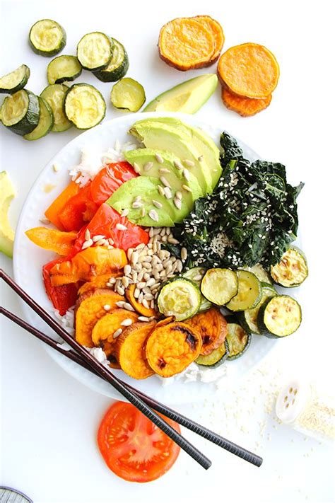 A White Plate Topped With Lots Of Veggies Next To Sliced Oranges And