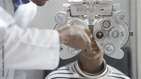 Optician Doing Optometry Eye Exam For Black African American Teen Girl