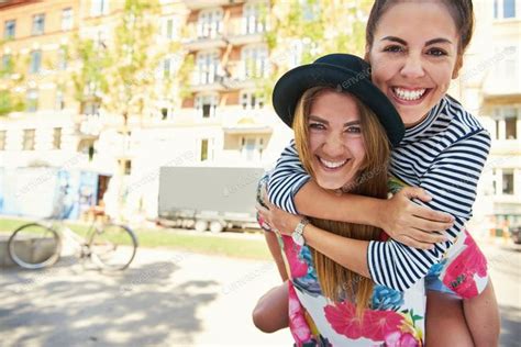 Two Laughing Girlfriends Holding Each Other Photo By Flamingoimages On