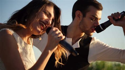 Slow Motion Shot Of Young Man And Woman Singing A Duet During Outdoor Musical Festival Stock