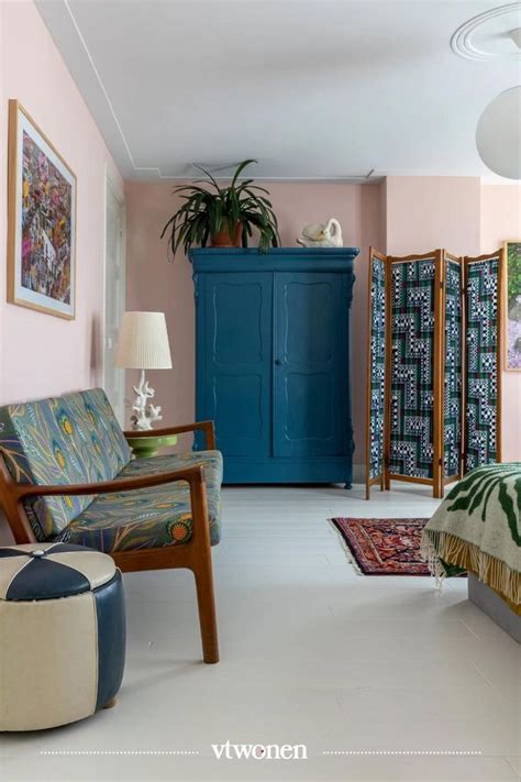 A Bedroom With Pink Walls Blue Cabinet And Colorful Furniture On The