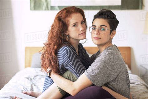 Portrait Of Lesbian Couple Relaxing On Bed At Home Stock