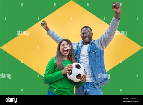 brazilian fans couple happy celebrating football or soccer game on yellow and green background