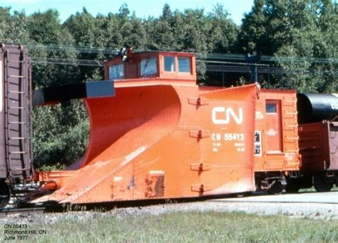 An Orange Train Car Sitting On The Tracks