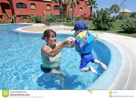 Sirva De Madre A Ayudar A Su Hijo Joven Nadar Y Saltar En Un Swimmin