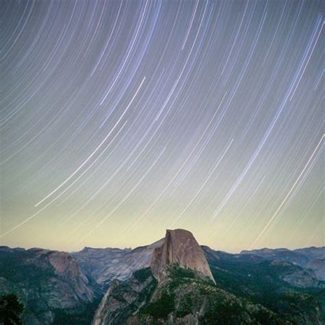 The Night Sky Is Filled With Star Trails And Stars In The Sky Above