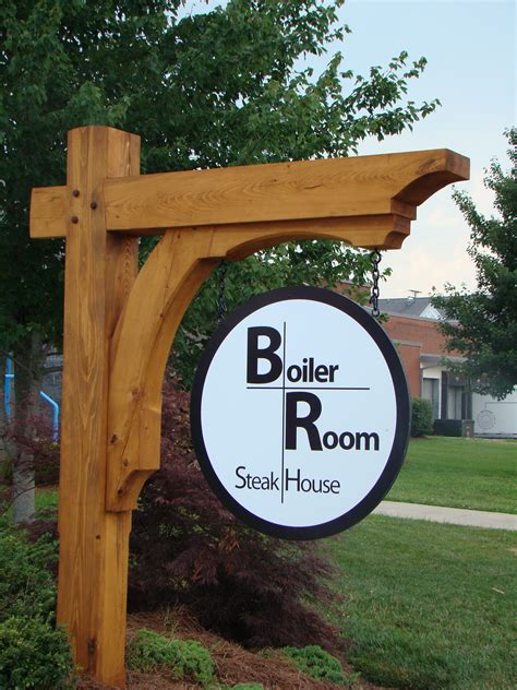 A Sign For Boiler Room In Front Of A Tree And Grass Area With Bushes