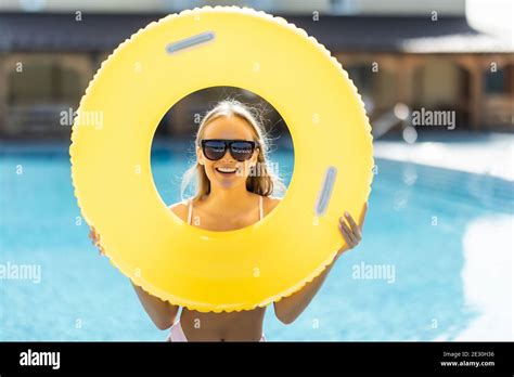 Beautiful Woman In Bikini Holding A Inflatable Ring At Poolside And Smiling Female Wearing