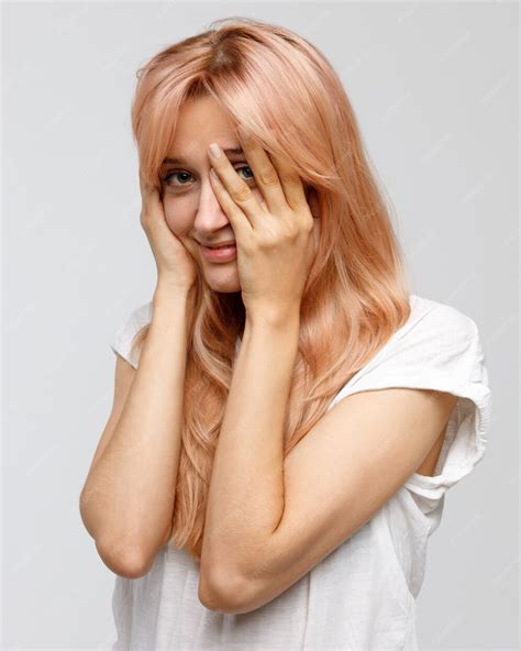 Premium Photo Shy Timid Woman With Long Blonde Hair Covering Her Face With Hand Smiling And