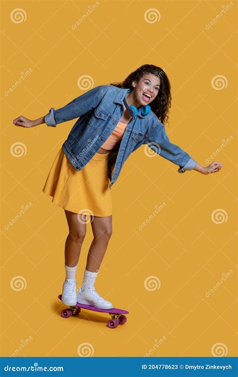 Pretty Dark Haired Young Girl On A Skateboard Having Good Time Stock