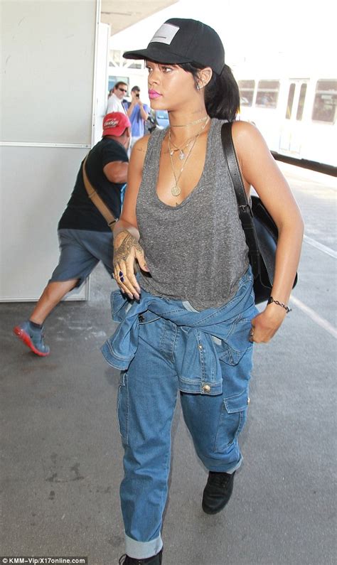 rihanna flashes some cleavage as she wears double denim for a flight out of town daily mail online