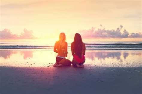 Two Young Women Watching The Sunset Over The Ocean Free Stock Photo