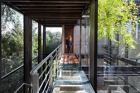 Outdoor Elevated Glass Walkway Connects Two Sections Of House