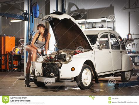 Uma Mulher Sexy Que Repara Um Carro Retro Em Uma Garagem Imagem De Stock Imagem De Feliz