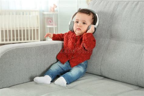 Música Que Escucha Del Bebé Lindo En Los Auriculares Foto De Archivo