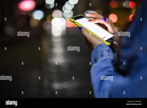 Girl Pointing Finger On Screen Smart Phone On Background Bokeh Light In