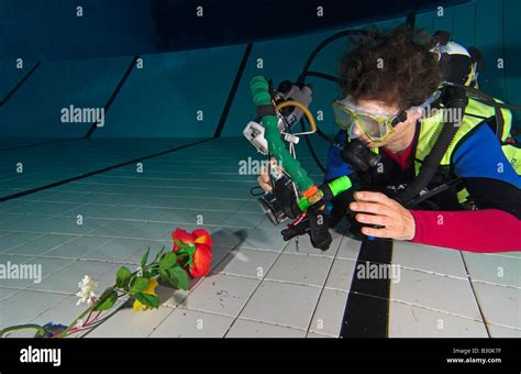 Woman Scuba Diver Practices Underwater Photography In Swimming Pool