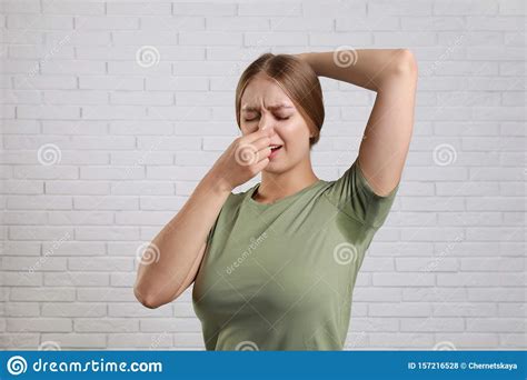 Young Woman With Sweat Stain On Her Clothes Against Brick Wall Stock