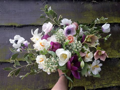 beautiful british wedding bouquet of spring flowers featuring hellebores anemones and