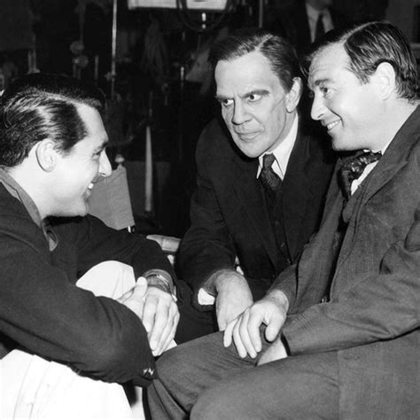 Three Men In Suits Sitting Next To Each Other Talking And Smiling At The Same Time