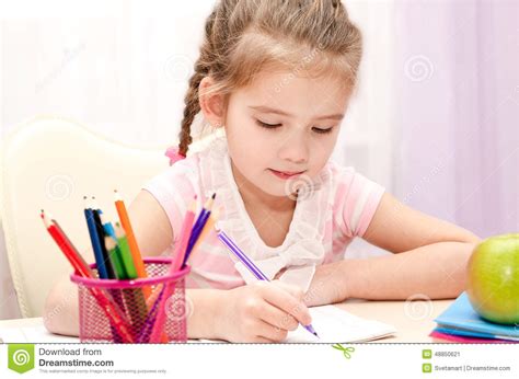 Cute Little Girl Is Writing At The Desk Stock Image Image Of Child