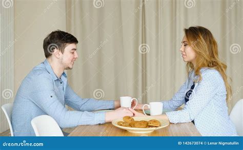 Couple Sits At Table Join Hands And Pray Before Breakfast Stock Photo