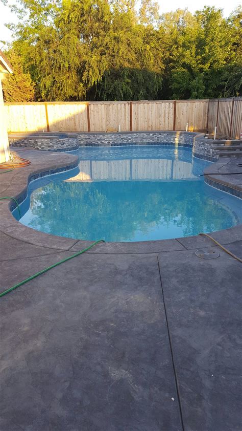 Stamped Concrete Pool With 3 Waterfalls On Wall And Grenadine Gray