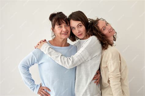 premium photo smiling mother hugging daughters and looking at camera