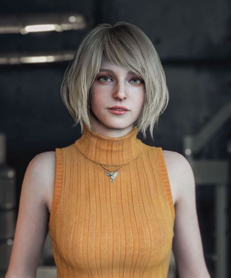 A Woman With Short Blonde Hair Wearing A Yellow Top And Gold Necklace Standing In Front Of A